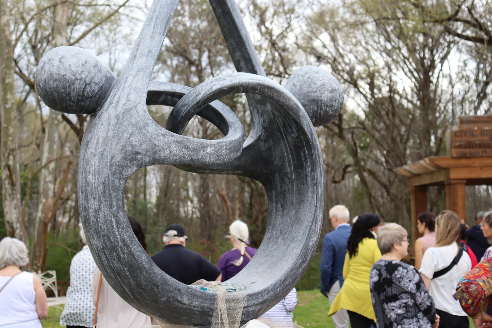 sculpture of two figures intertwined, forming a circle