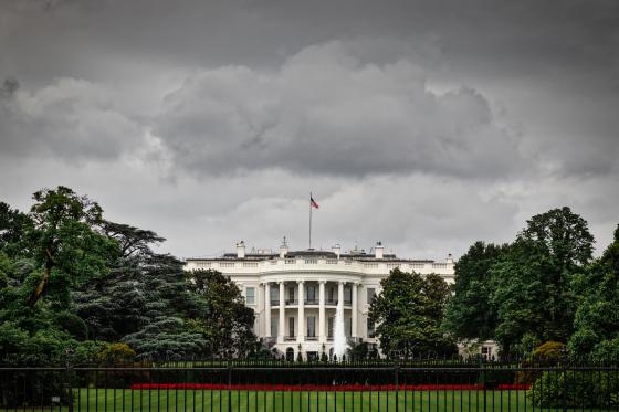 image of the White House with dark sky looming overhead