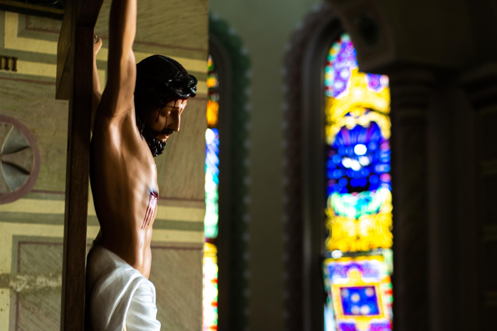 Church crucifix in front of stained glass windows