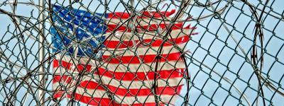 American flag behind barbed wire