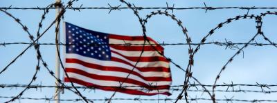 American flag behind barbed wire