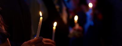 People holding candles in the dark