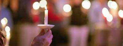 Hand holding a candle at prayer vigil