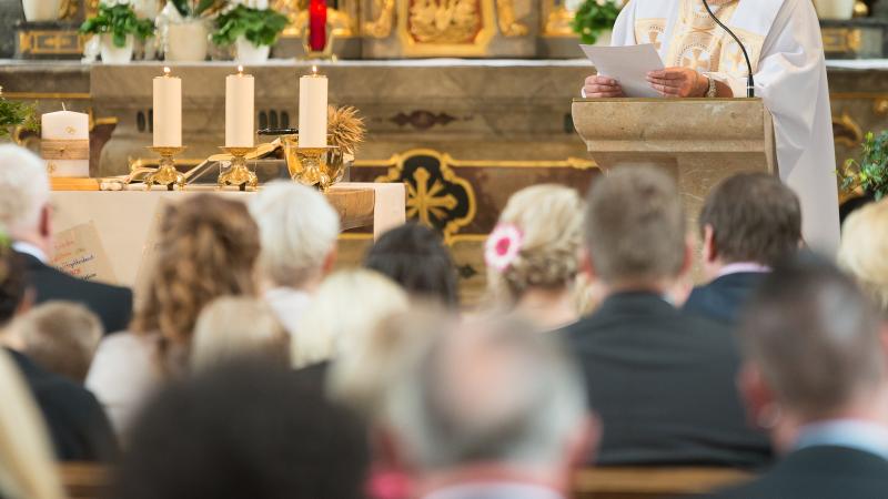 priest preaching to congregation