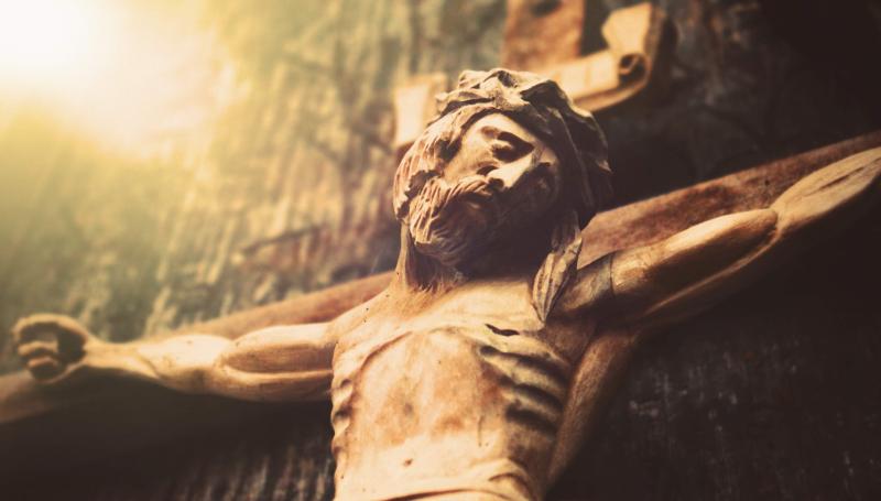 Wooden crucifix with light beaming from one corner