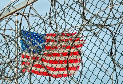 American flag behind barbed wire